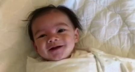 Babyen våkner med et smil – men se når mamma tar av teppet. Så søtt!