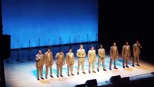 Ti menn står på scenen og gjør en vanvittig kul versjon av «The Lion Sleeps Tonight»