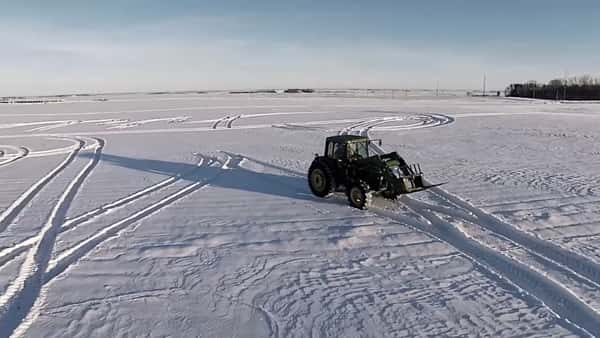 Bonden ser at snøen har lagt seg på jordet – da tar han traktoren og skriver en hilsen i snøen – så fint!