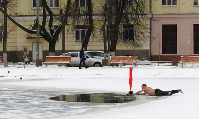 Mannen kaster av seg jakken og løper bort til hullet i isen, det han gjør fortjener en medalje!